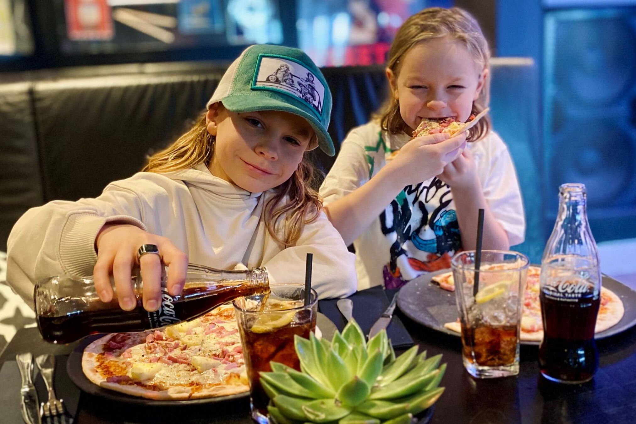 Två barn äter pizza på Leif's Pizzeria.